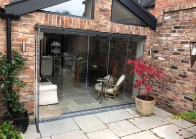 Slimline bifold sliding concertina patio doors installation between a living room and patio