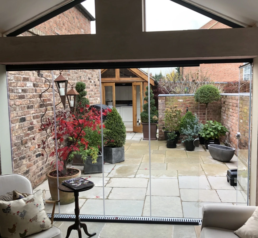 external frameless glass bifold doors by a patio of a home in the uk