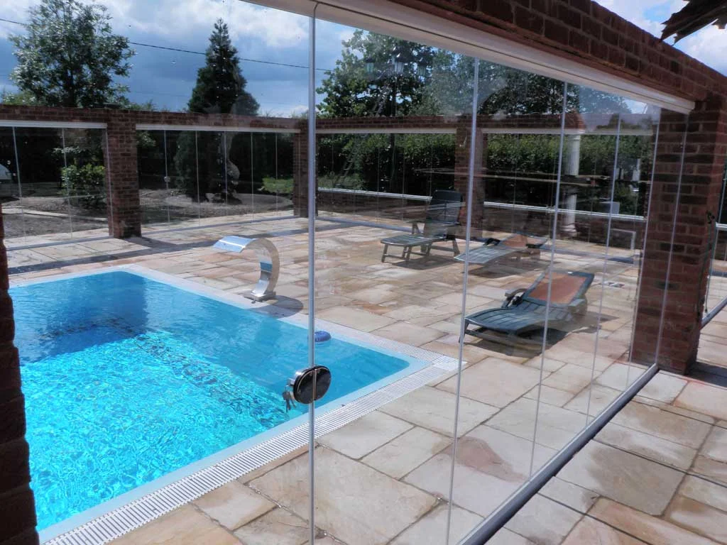 frameless glass room dividers surrounding a pool