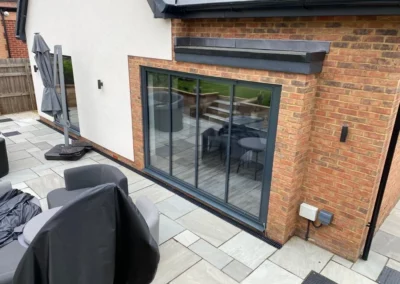 Ultra slim bi fold doors by a patio. Brick home, UK