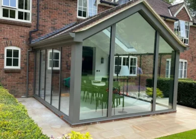 Modern ultra slim bifold glass doors with panoramic views over a garden, UK