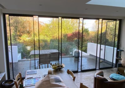 Minimal glass doors installed overlooking a patio in the UK. Black minimal aluminium frames.