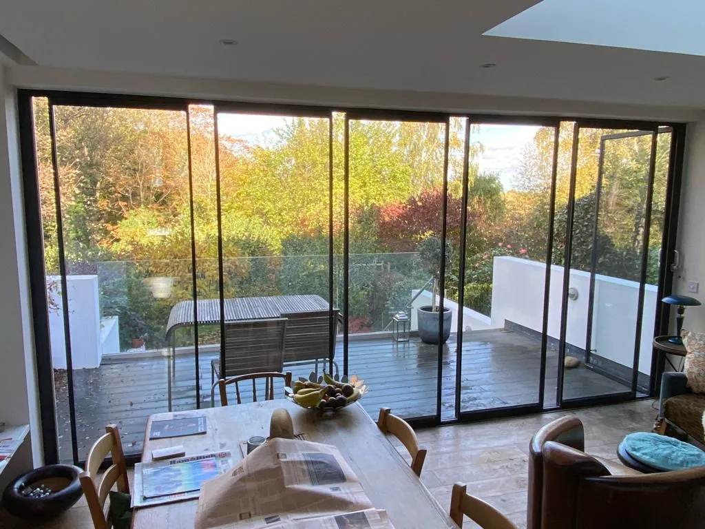 Minimal glass doors installed overlooking a patio in the UK. Black minimal aluminium frames.
