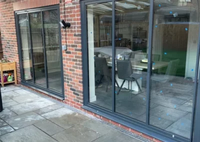 Ultra slim bifolding doors by a patio. Brick home, UK