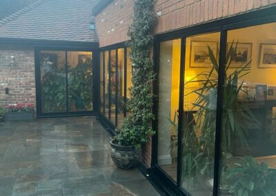 Ultra slim sliding doors by a patio. Brick home, UK