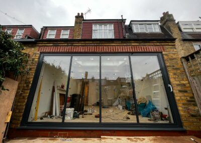 Frameless sliding doors by a patio. Brick home, UK