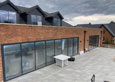 Slim frame sliding doors by a patio. Brick home, UK