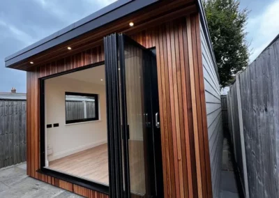 Ultra thin bifolding doors by a patio. Wooden home, UK