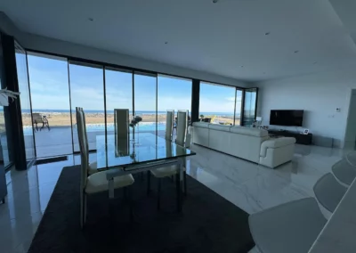 Slimmest ultra slim bifold doors in a living room overlooking the sea, letting lots of natural light in