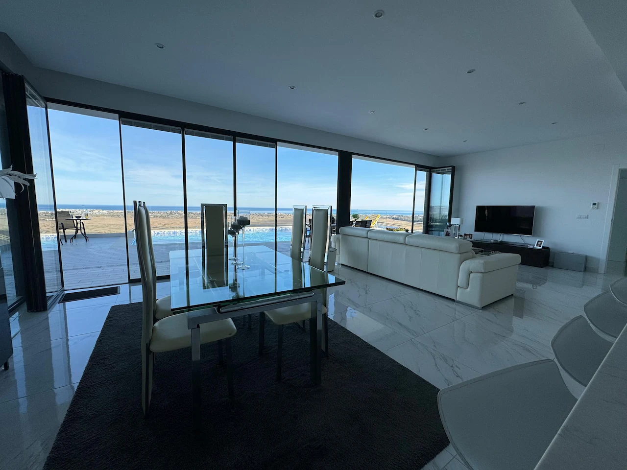 Slimmest ultra slim bifold doors in a living room overlooking the sea, letting lots of natural light in