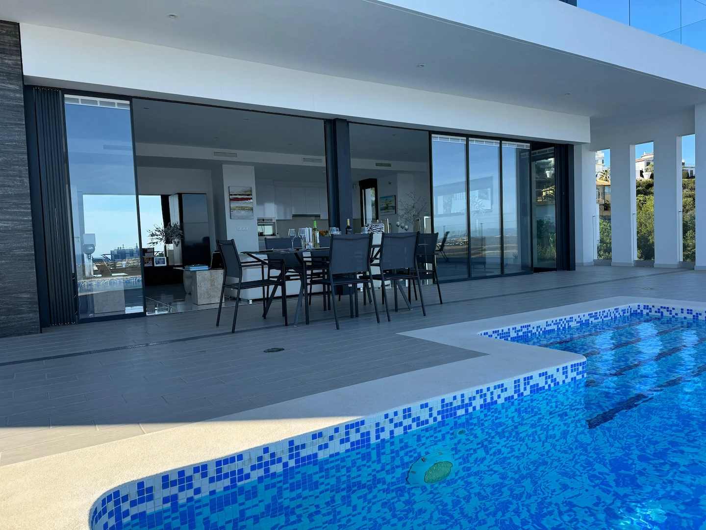 Ultra slim sliding doors installed by a pool in a contemporary home
