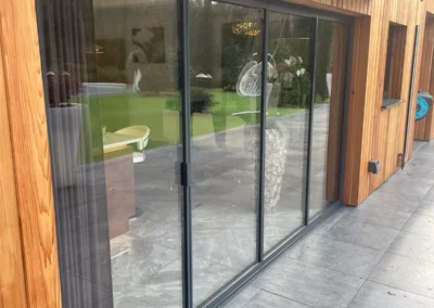 Ultra slim sliding doors installation in the UK on a wooden modern home. By Vision Glass Doors