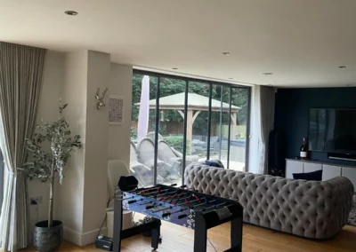 Ultra slim sliding doors installation in the UK on a modern home looking out onto a garden from a living room