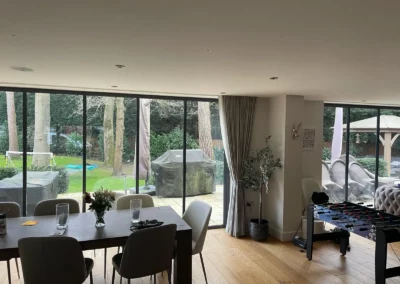 Ultra slim sliding doors installation in the UK on a modern home looking out onto a garden from a living room