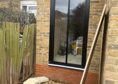 Ultra slim sliding doors installation in the UK on a modern home by a patio. By Vision Glass Doors