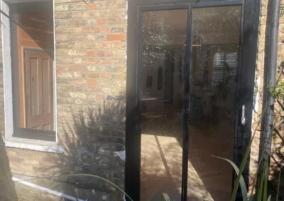 Ultra slim sliding doors installation in the UK on a modern home by a patio. By Vision Glass Doors