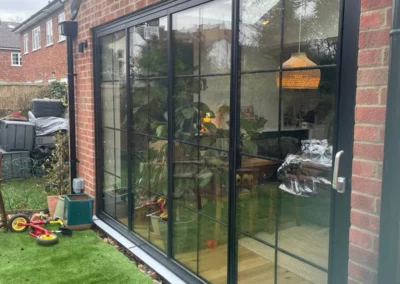 Ultra slim sliding doors looking in from the garden. Brick home, UK