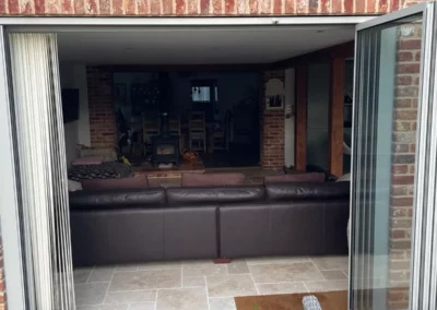 Ultra slim sliding doors by a patio. Brick home, UK