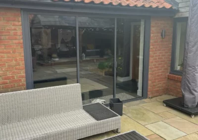 Ultra slim bifolding doors by a patio. Brick home, UK