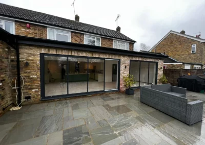 Ultra slim sliding doors installation in the UK on a modern home by a patio. By Vision Glass Doors