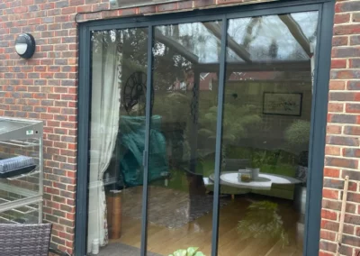 Ultra slim bifolding doors by a patio. Brick home, UK