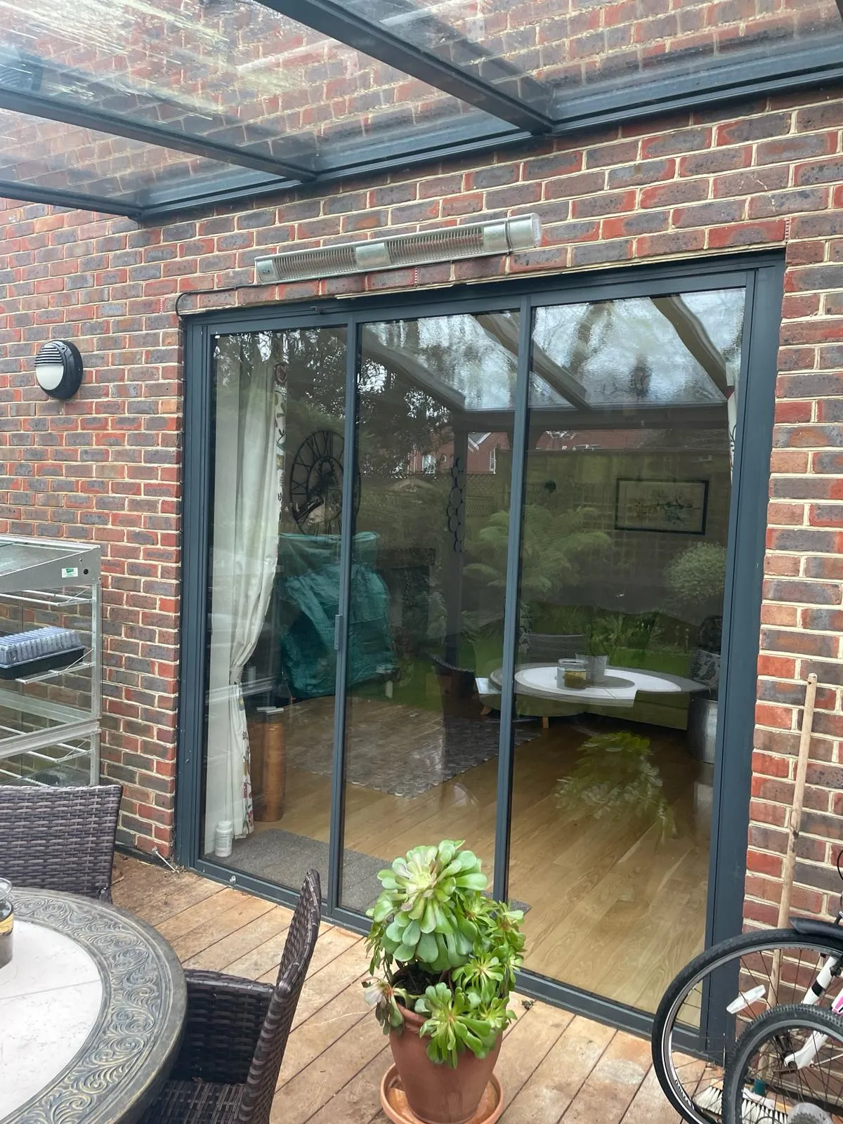 Ultra slim bifolding doors by a patio. Brick home, UK