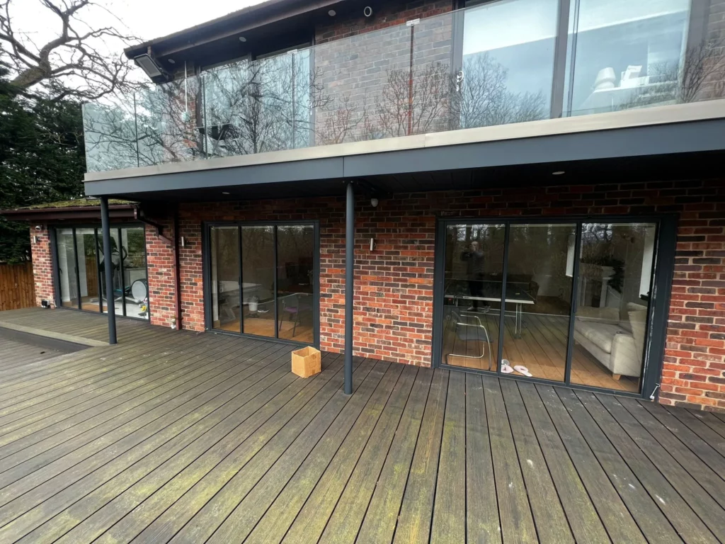 Folding sliding glass doors by a patio. Brick home, UK