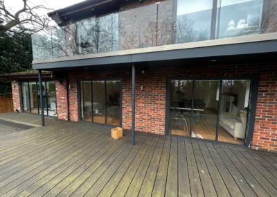 Folding sliding glass doors by a patio. Brick home, UK