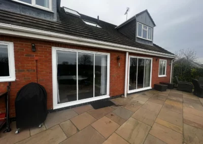 Ultra slim uPVC bifolding doors by a patio. Brick home, UK