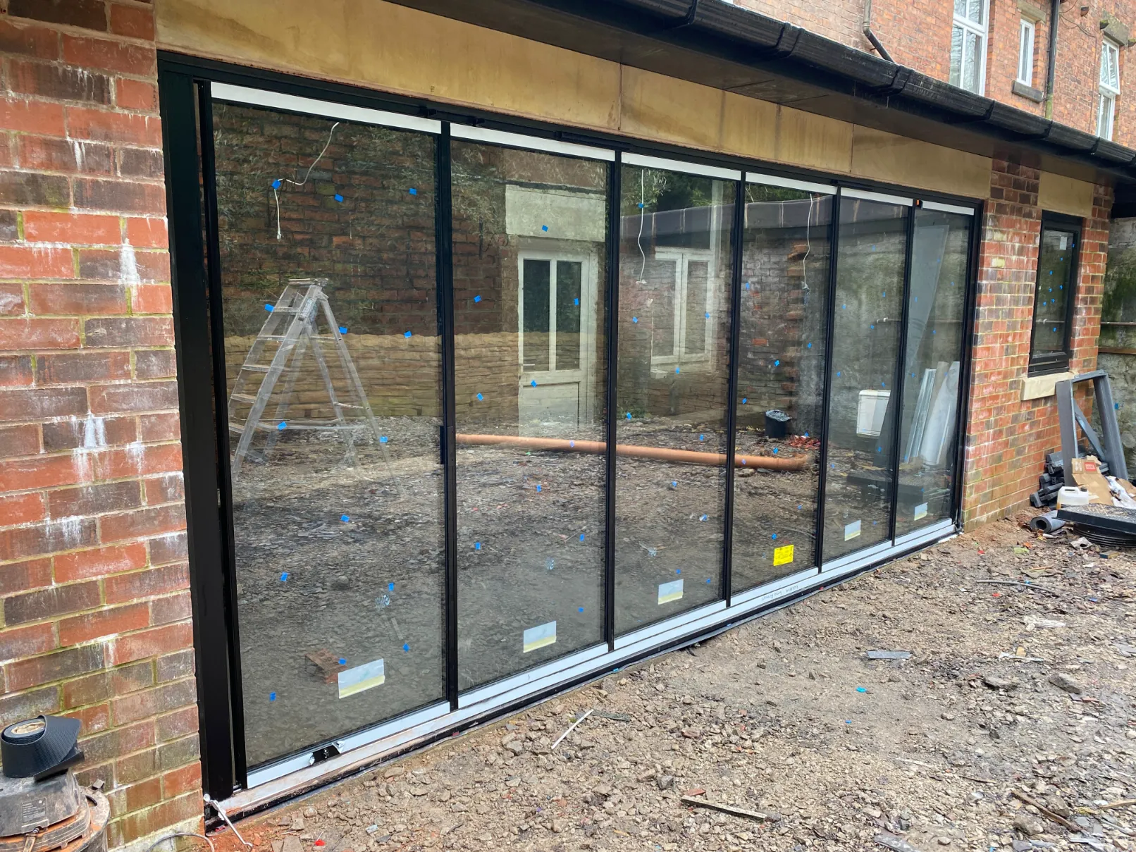 Minimal glass doors installed overlooking a patio in the UK. Black minimal aluminium frames.